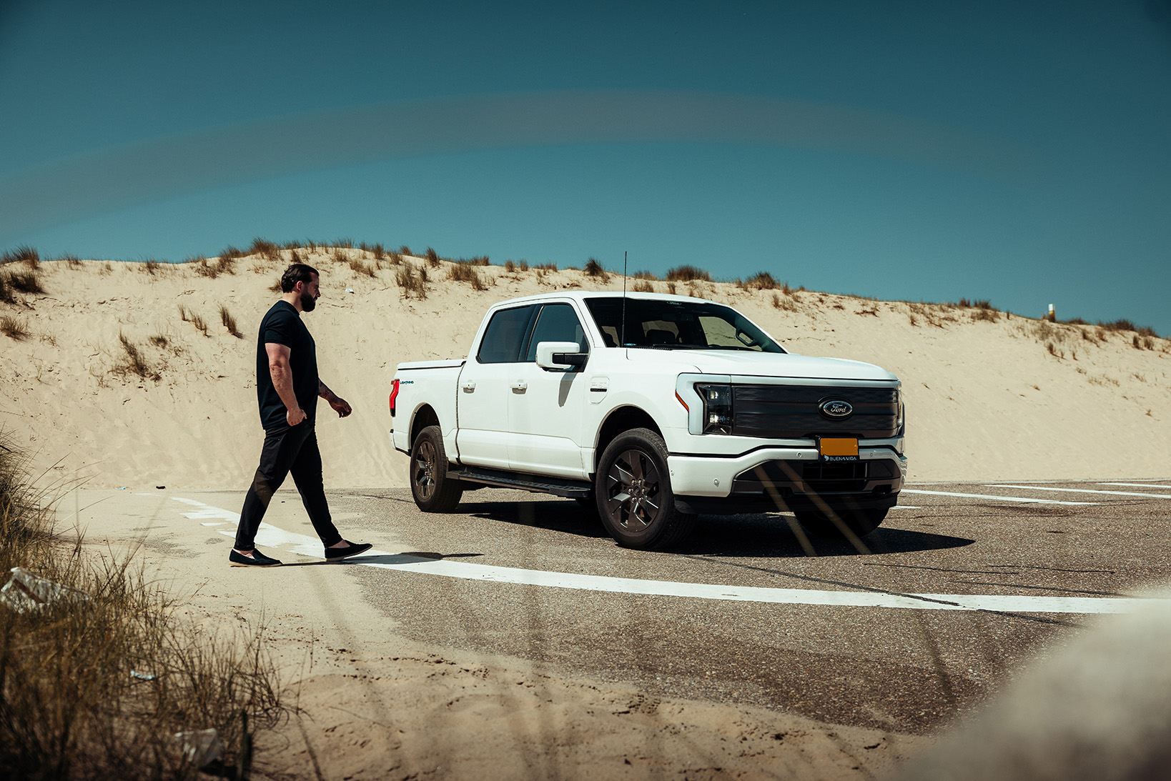 Ford F-150 Lightning wit schuin van voren met persoon