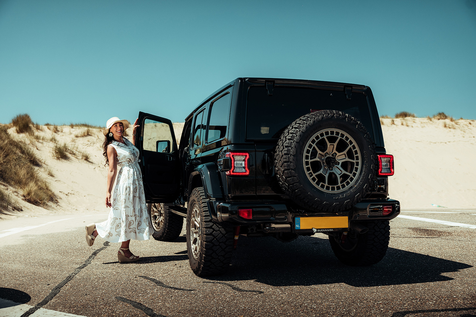 Jeep wrangler zwart achterkant met persoon die deur opent