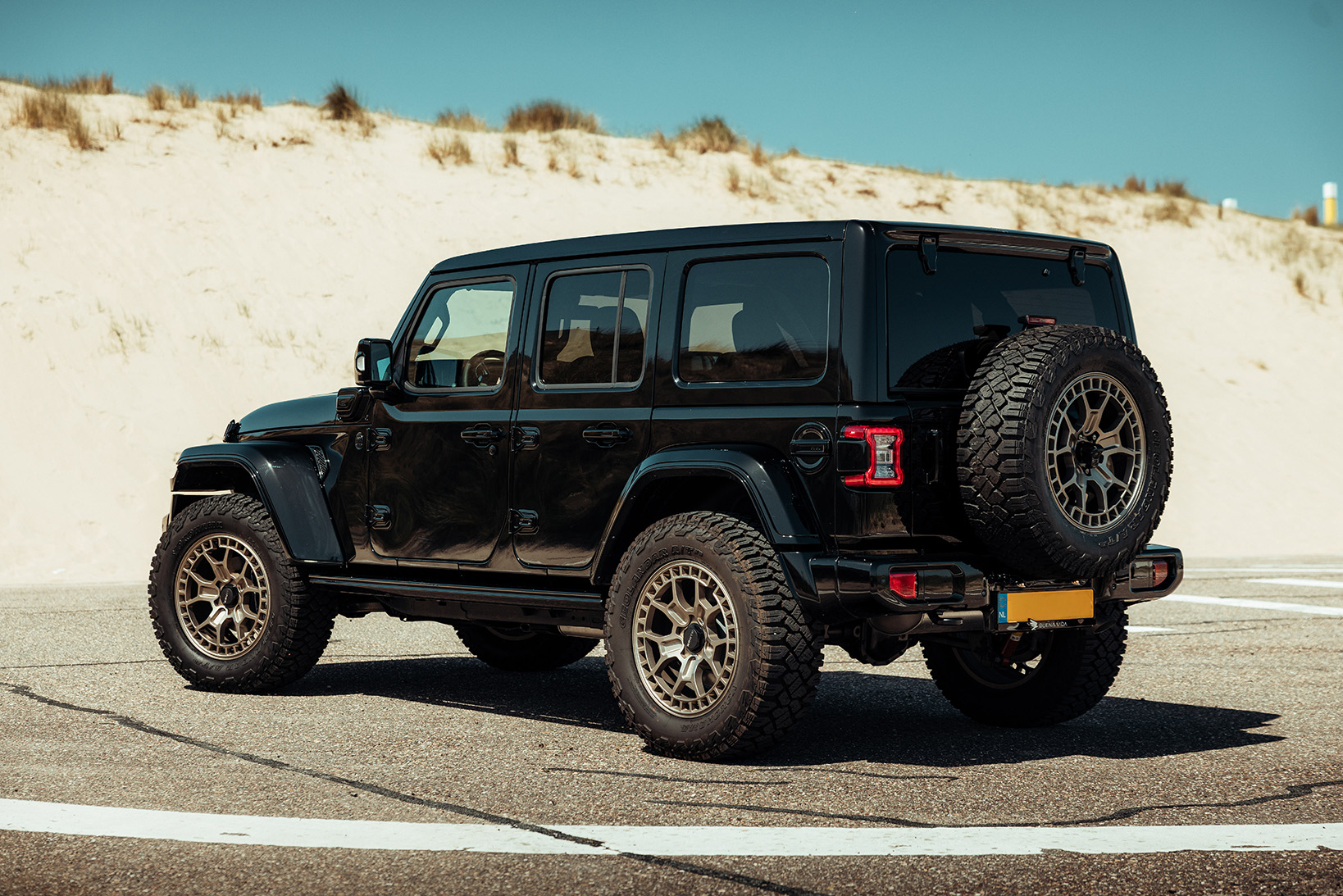 Jeep wrangler zwart schuin van achteren